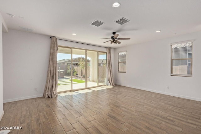 empty room with ceiling fan and light hardwood / wood-style floors