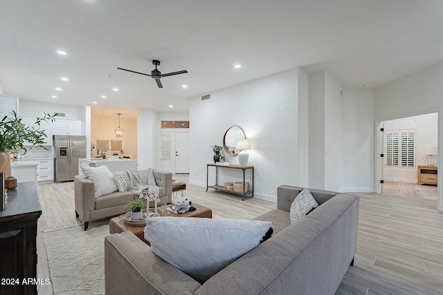 living room featuring ceiling fan, sink, and light hardwood / wood-style flooring