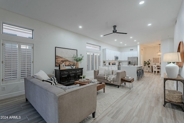 living room featuring ceiling fan and light hardwood / wood-style flooring