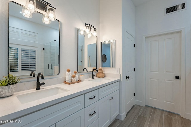 bathroom featuring hardwood / wood-style flooring, vanity, and walk in shower