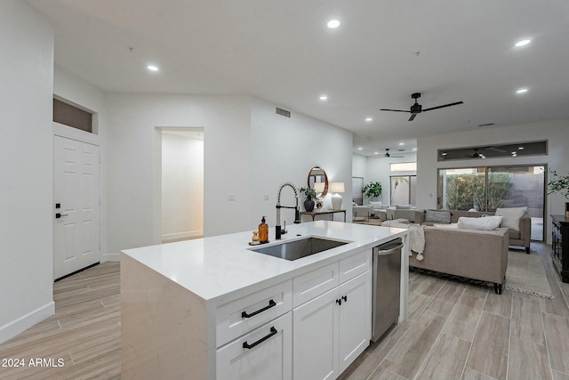 kitchen with dishwasher, sink, an island with sink, light hardwood / wood-style floors, and white cabinetry