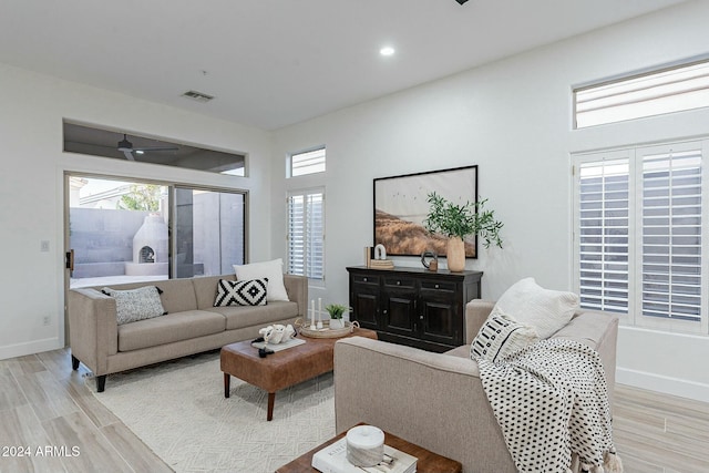 living room with ceiling fan and light hardwood / wood-style flooring