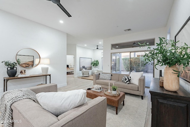 living room featuring light hardwood / wood-style flooring and ceiling fan