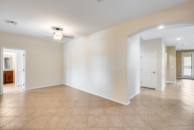 9165 W Mine Trl, Peoria, AZ 85383 - empty room featuring light tile patterned flooring, arched walkways, a ceiling fan, baseboards, and recessed lighting