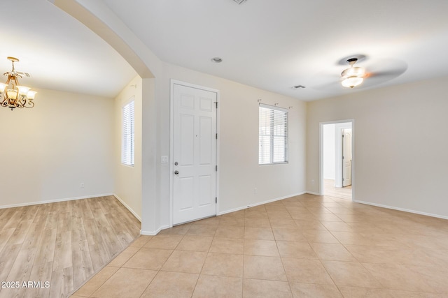 9165 W Mine Trl, Peoria, AZ 85383 - unfurnished room featuring arched walkways, plenty of natural light, a chandelier, and baseboards