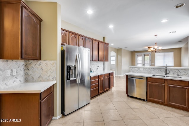 9165 W Mine Trl, Peoria, AZ 85383 - kitchen featuring stainless steel appliances, a sink, tasteful backsplash, a chandelier, and light tile patterned flooring