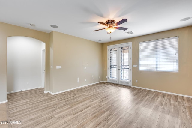 9165 W Mine Trl, Peoria, AZ 85383 - unfurnished room featuring a ceiling fan, arched walkways, light wood-style flooring, and baseboards