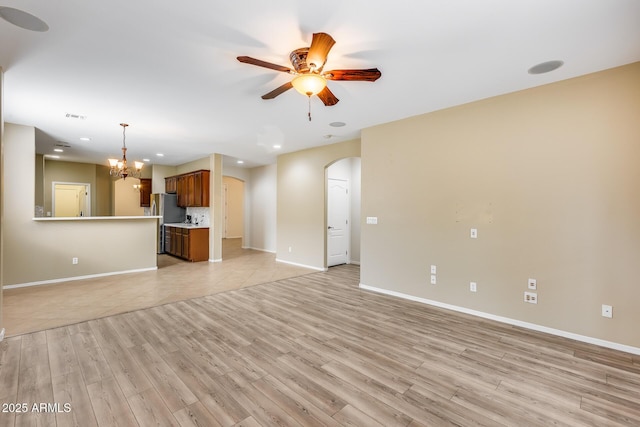 9165 W Mine Trl, Peoria, AZ 85383 - unfurnished living room with arched walkways, a ceiling fan, light wood-type flooring, baseboards, and recessed lighting