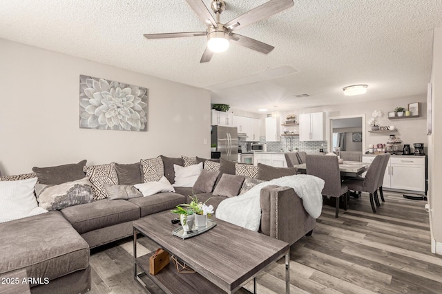 6802 S 47th St, Phoenix, AZ 85042 - living room with a textured ceiling, light wood-style flooring, and a ceiling fan