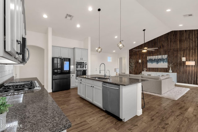 kitchen with white cabinets, black appliances, sink, and an island with sink