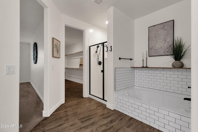 bathroom featuring independent shower and bath and hardwood / wood-style floors