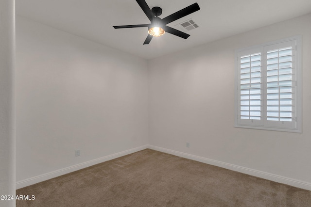 carpeted spare room with ceiling fan