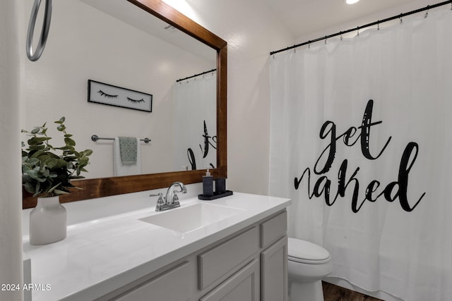 bathroom featuring toilet, vanity, hardwood / wood-style floors, and curtained shower