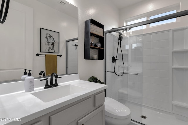 bathroom with walk in shower, vanity, and toilet