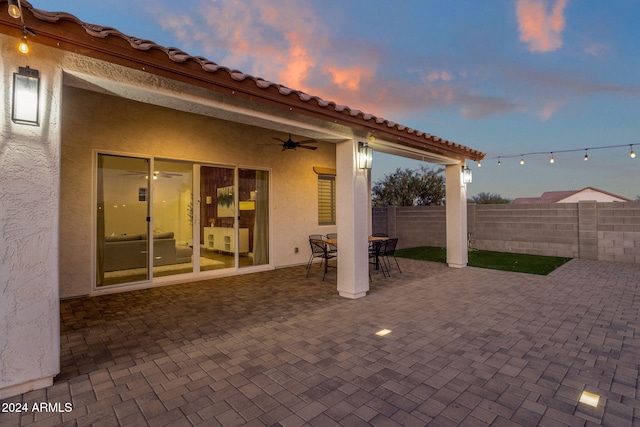 patio terrace at dusk featuring ceiling fan