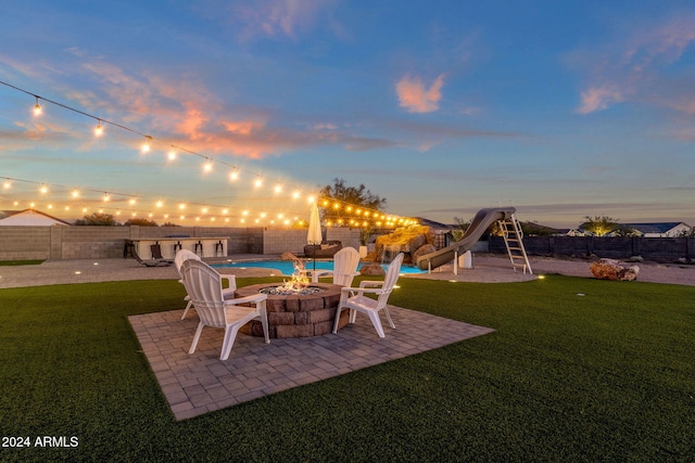 yard at dusk with an outdoor fire pit and a patio area