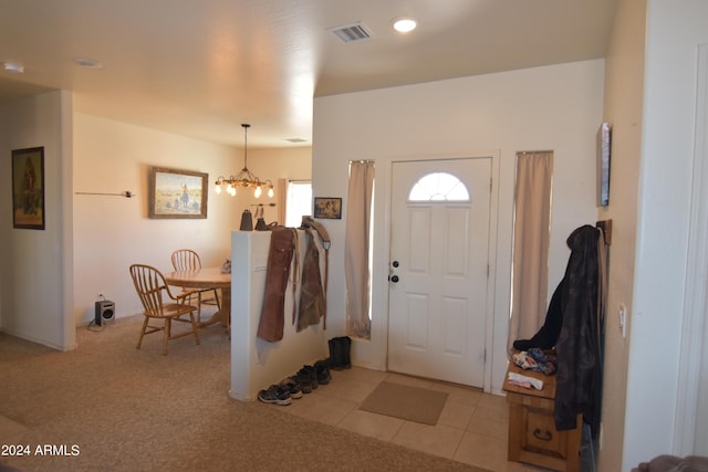 foyer featuring light tile patterned floors and a chandelier