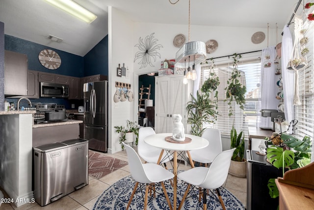 dining space featuring light tile patterned floors and high vaulted ceiling