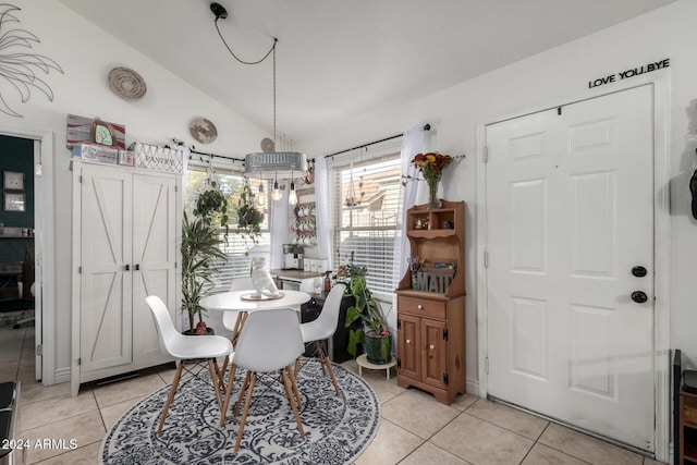 dining space featuring light tile patterned floors and vaulted ceiling