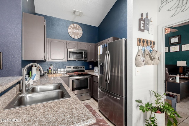 kitchen with gray cabinets, light tile patterned flooring, sink, and appliances with stainless steel finishes