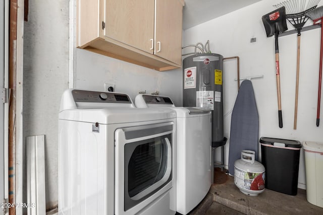 clothes washing area featuring cabinets, electric water heater, and washer and dryer