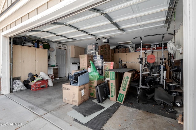 garage with a garage door opener and washer / dryer