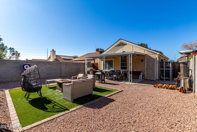 back of property featuring a yard, a patio, and an outdoor hangout area