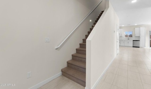 staircase featuring sink and tile patterned floors