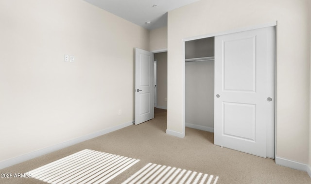 unfurnished bedroom with light carpet and a closet