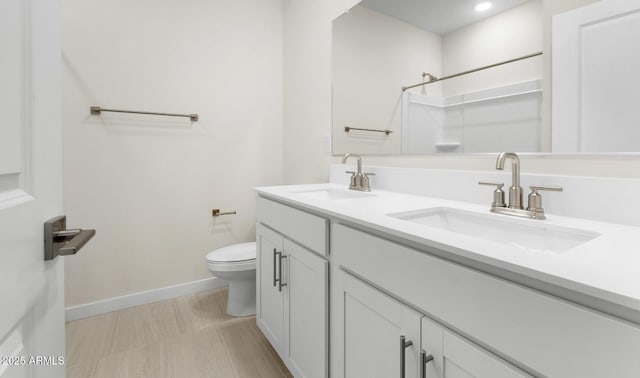 bathroom featuring vanity, toilet, and walk in shower