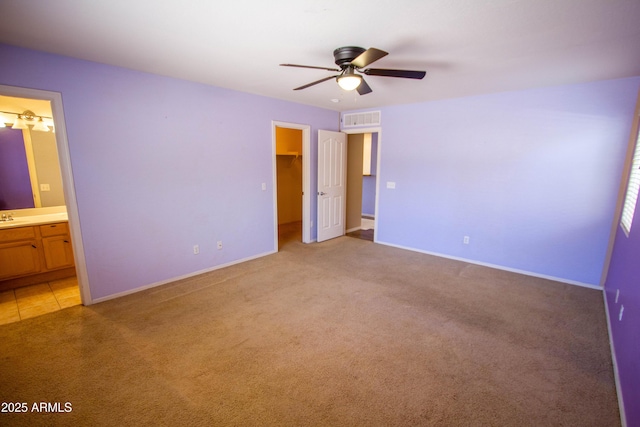 44944 W Miramar Rd, Maricopa, AZ 85139 - unfurnished bedroom featuring light colored carpet, a walk in closet, ensuite bath, baseboards, and a closet