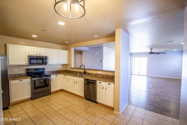 44944 W Miramar Rd, Maricopa, AZ 85139 - kitchen featuring stainless steel appliances, a sink, light tile patterned floors, dark countertops, and recessed lighting