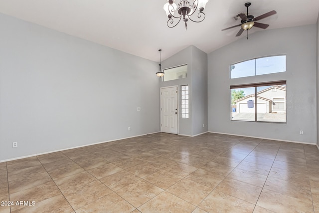 tiled empty room with ceiling fan with notable chandelier and lofted ceiling