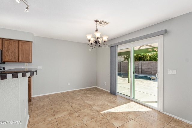 unfurnished dining area featuring light tile patterned floors and an inviting chandelier