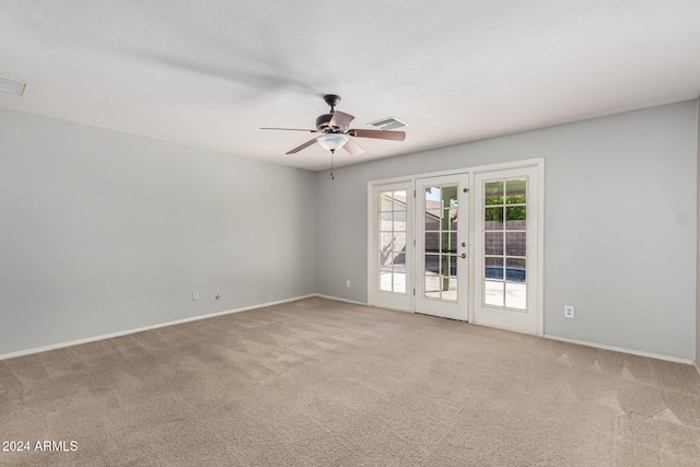 carpeted spare room with french doors and ceiling fan