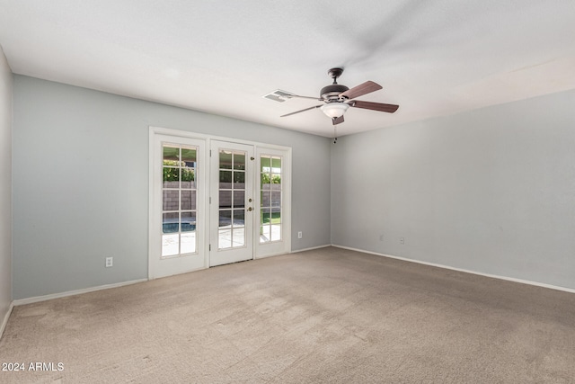 carpeted empty room featuring ceiling fan and french doors