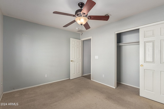 unfurnished bedroom featuring ceiling fan, a closet, and light carpet