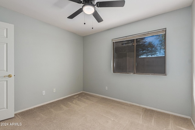 unfurnished room with light colored carpet and ceiling fan