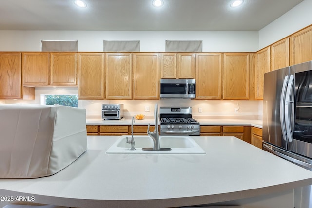 kitchen featuring light brown cabinetry, sink, and stainless steel appliances