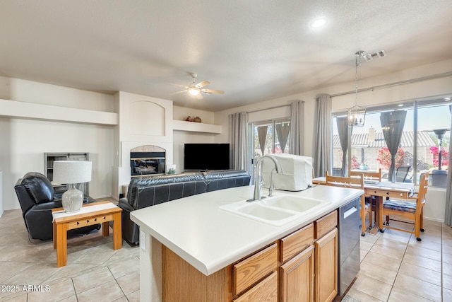 kitchen with dishwasher, sink, a center island with sink, and light tile patterned floors