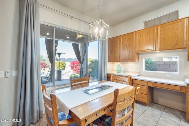 kitchen with hanging light fixtures, built in desk, and light tile patterned floors