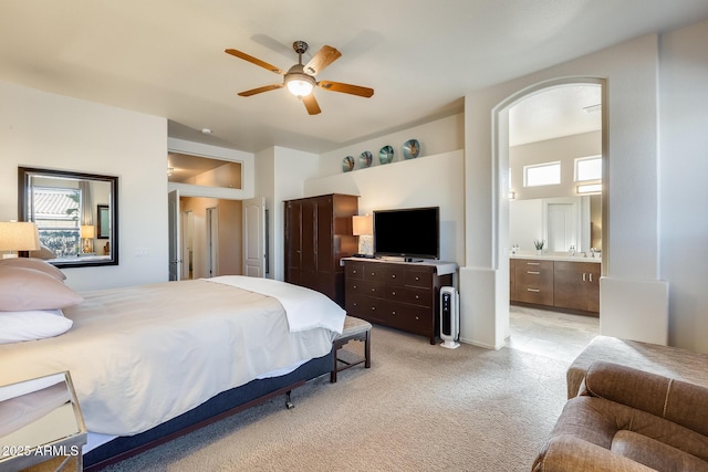 carpeted bedroom featuring ceiling fan and ensuite bath