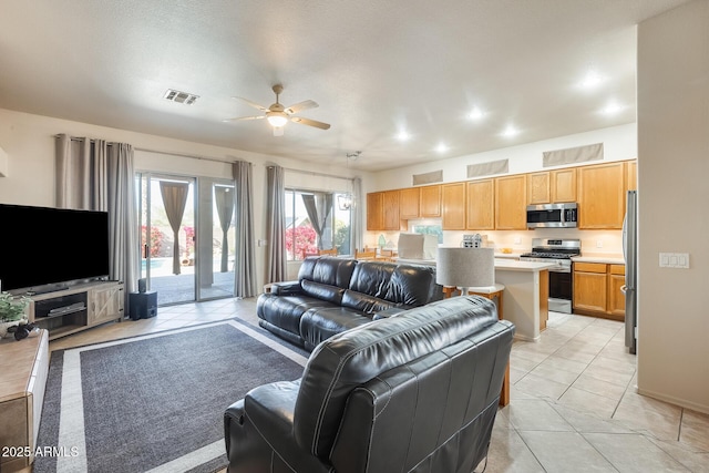 tiled living room with ceiling fan and a textured ceiling