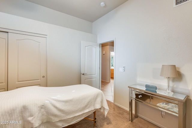 bedroom with light carpet and a closet