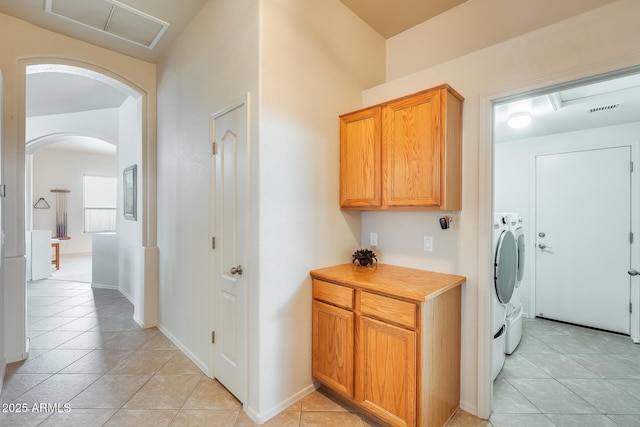 laundry area with washer and dryer and light tile patterned floors