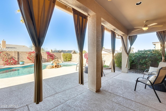 view of patio featuring a fenced in pool and ceiling fan