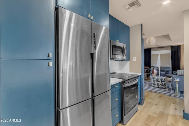 kitchen with appliances with stainless steel finishes, light hardwood / wood-style flooring, and blue cabinets