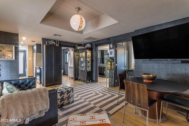 living room featuring light hardwood / wood-style floors and a raised ceiling