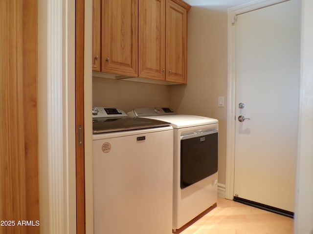 laundry area featuring cabinets and washing machine and clothes dryer