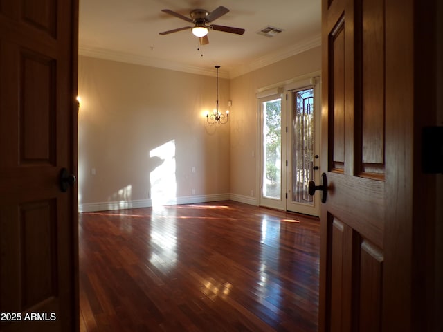 empty room featuring crown molding, dark hardwood / wood-style floors, and ceiling fan with notable chandelier